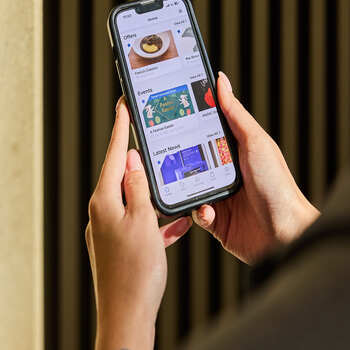 A person browses offers and news on The Palms Shopping Village app on their smartphone.